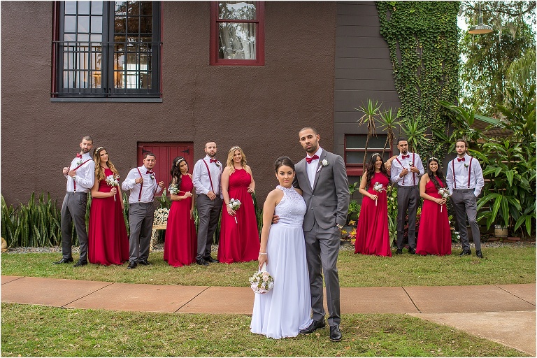 the wedding party with their ruby red bridesmaids dresses and red bowties and suspenders
