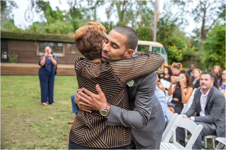 the groom hugs his grandmother who walked him down the aisle