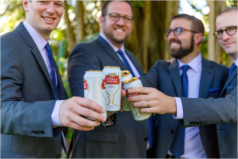 the groom & groomsmen cheers with cans of Stella Artois