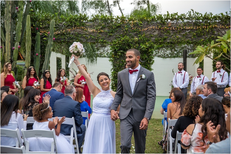 the bride celebrates as they walk back down the aisle together as man and wife