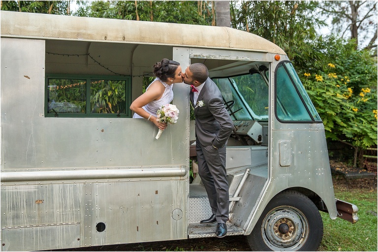 the bride leans out the van window to kiss her new husband