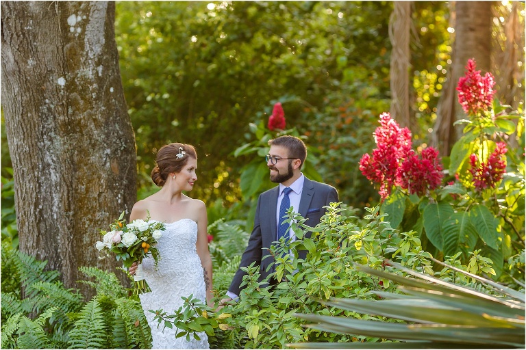 the bride and groom emerge from the lush greenery at Marie Selby Botanical Gardens