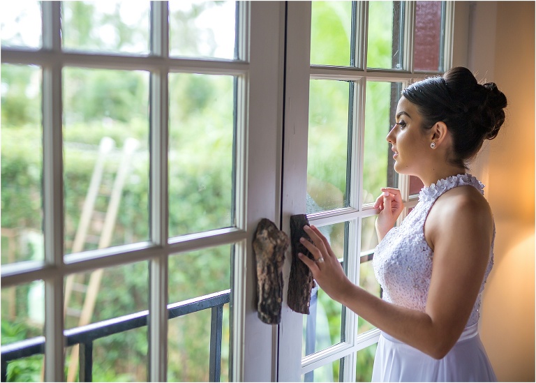 the bride gazes out the window before her ceremony at the acre orlando