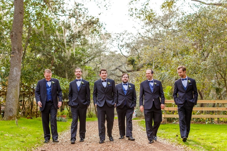 the groom & his groomsmen take a stroll in their black Men's Warehouse tuxedos with royal blue accessories 