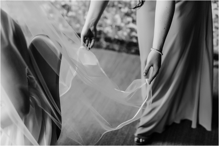 A bridesmaid adjusts the bride's veil in Tampa's Oxford Exchange