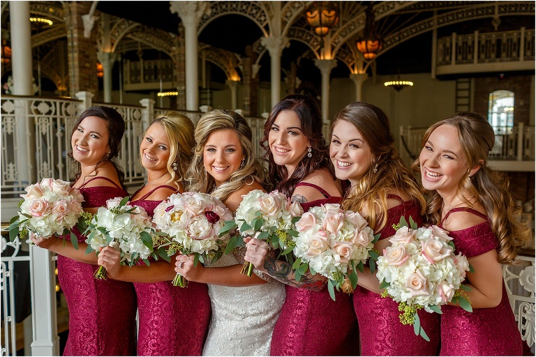 the bride and her bridesmaids smile with their white and blush Atmosphere Floral bouquets at the Orchid Garden Orlando
