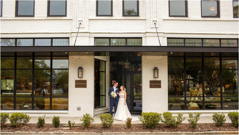 the bride & groom share a moment outside Oxford Exchange as he carries her bouquet for her
