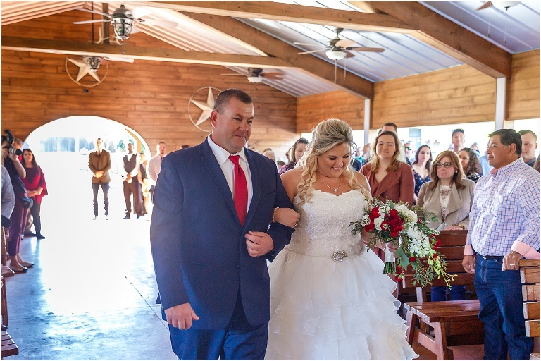 the bride smiles as her father gives her away in front of all their loved ones at Hidden Barn Venue
