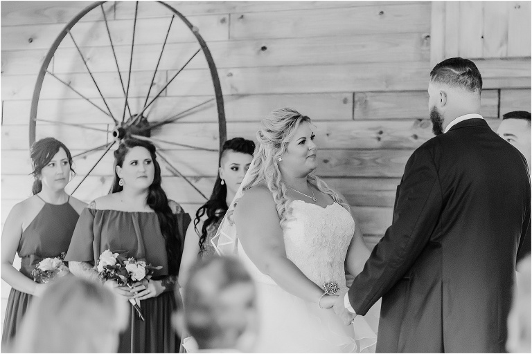the bride looks lovingly at her groom as they exchange vows in their Hidden Barn Venue ceremony
