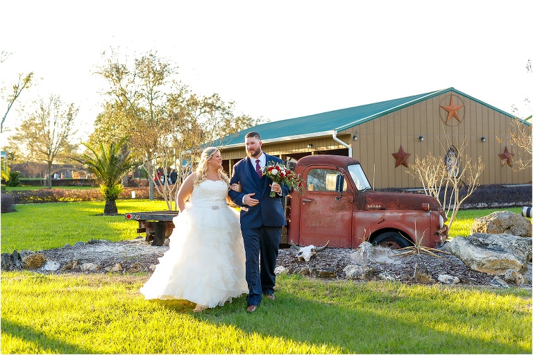 the bride & groom walk arm in arm at the rustic Hidden Barn Venue in Apopka, FL