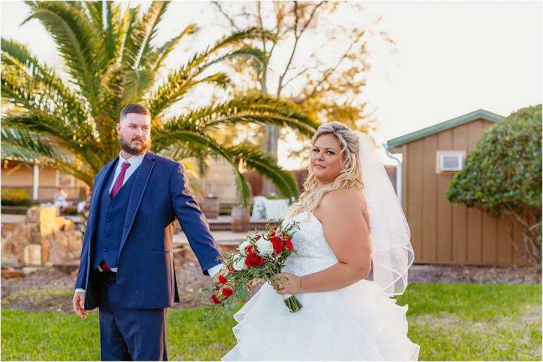 the groom leads his bride around the lush grounds of Hidden Barn Venue