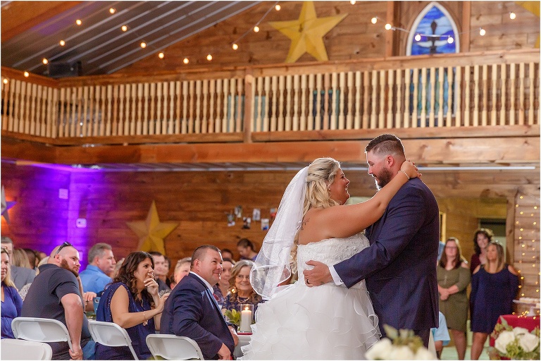 the bride & groom share their first dance as husband and wife under the Hidden Barn Venue's market lights