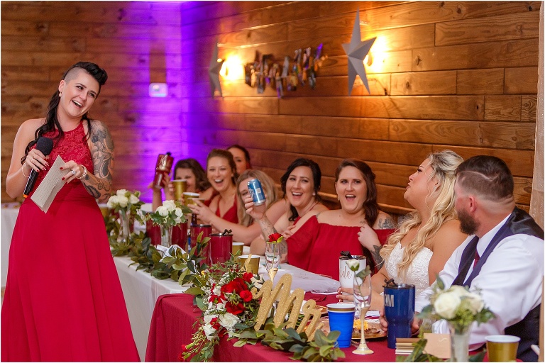 the bride & groom laugh as the matron of honor shares a particularly funny story during her toast