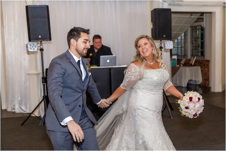 the bride smiles at her new husband as they prepare for their first dance at their Orchid Garden reception