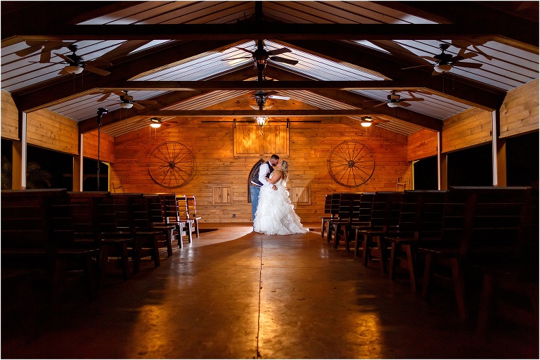 bride & groom kiss in the rustic wooden chapel at Hidden Barn Venue