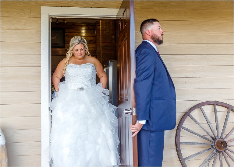 the groom waits for his bride to grab his hand during their first touch at Hidden Barn Venue