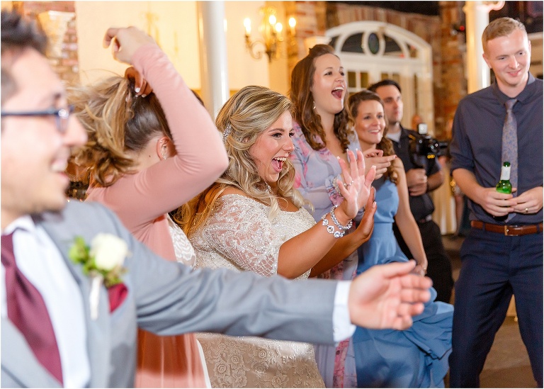 the bride and her friends cheer and laugh as they watch her new husband dance the night away to Fyerfly Productions' playlist