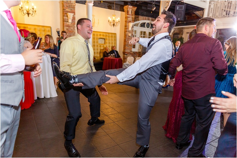 the groom uses his leg as a guitar at their Orchid Garden at Church Street Station wedding reception