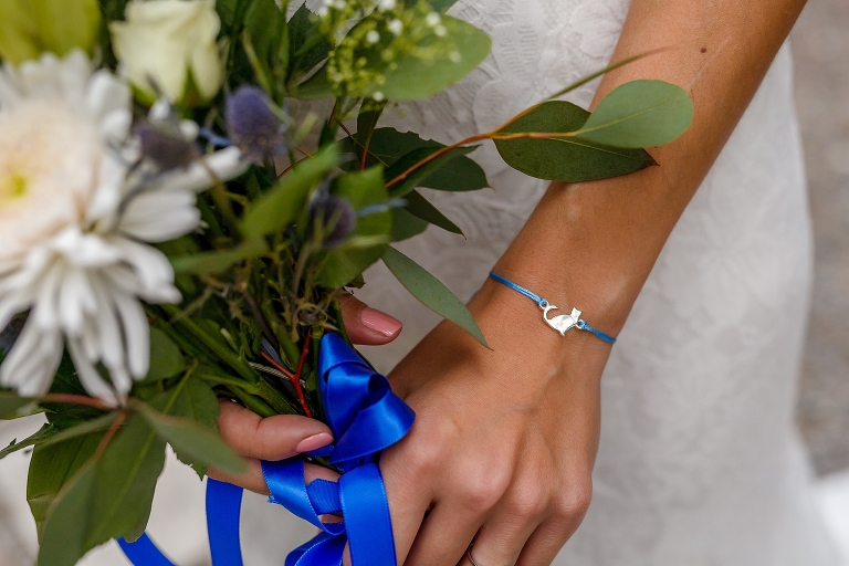 the bride's "something blue", a tiny blue bracelet with a small silver cat pendant
