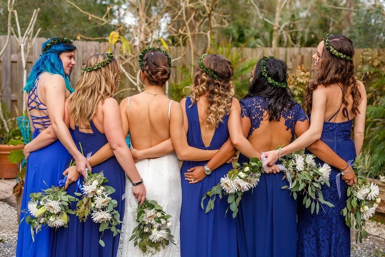 the bride & her bridesmaids, arms around each other, showing off the backs of their royal blue Lulu's bridesmaids dresses
