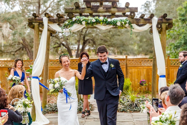 the bride & groom walk back down the aisle as husband & wife as their loved ones cheer