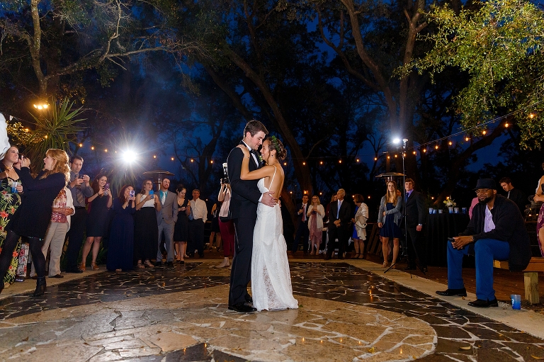 the bride and groom share their first dance under the market lights at their DIY garden wedding reception