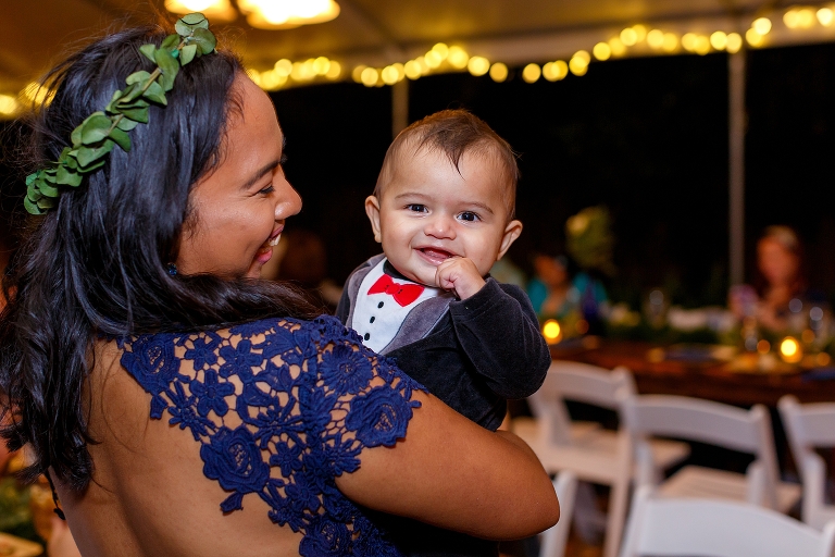 the littlest wedding guest giggles during their DIY garden wedding reception