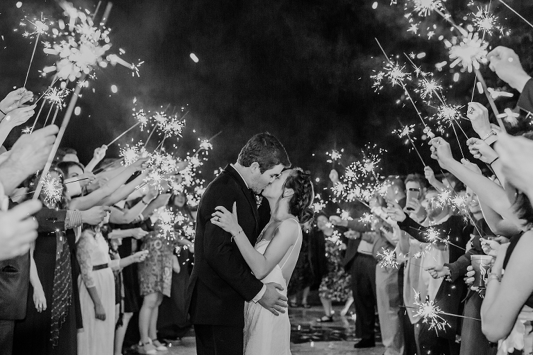 the bride & groom kiss under the sparklers during their grand exit from their DIY garden wedding