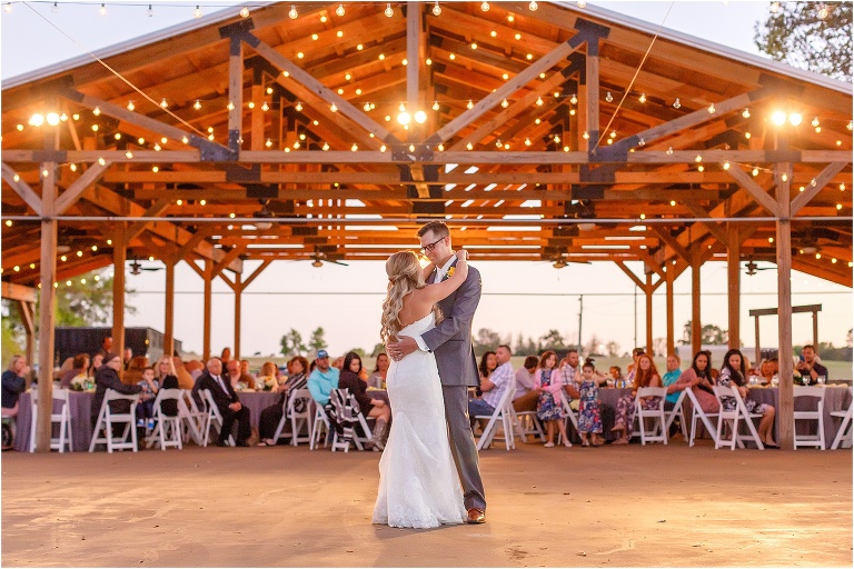 the bride & groom share their first dance as husband and wife under the market lights at their Cottom Farm wedding reception