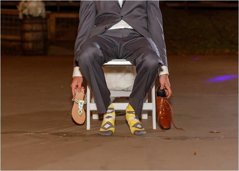 the groom sits in his socks while they play the shoe game at their Cottom Farm wedding reception
