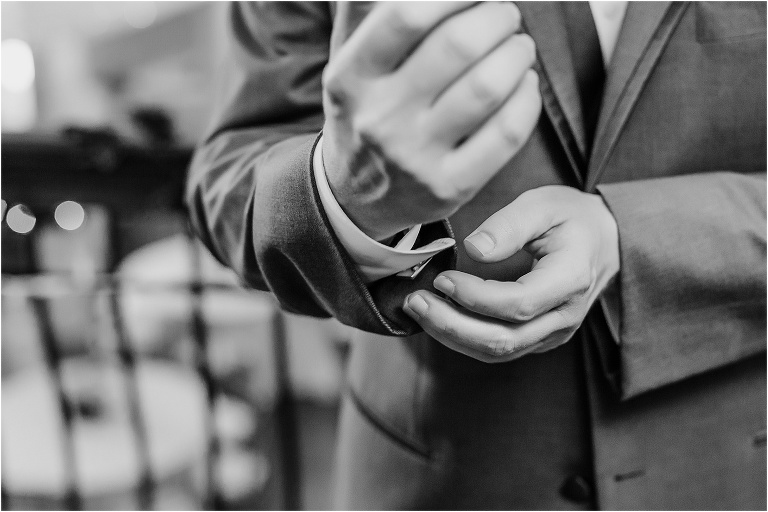the groom's hands finish up fastening his cuff links before his Bakers Ranch wedding