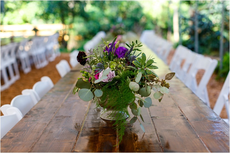 purple roses accent the floral centerpieces at the Harmony Gardens wedding venue