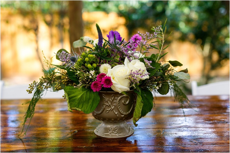 pink and purple accented floral centerpieces on beautiful weathered wooden farm table