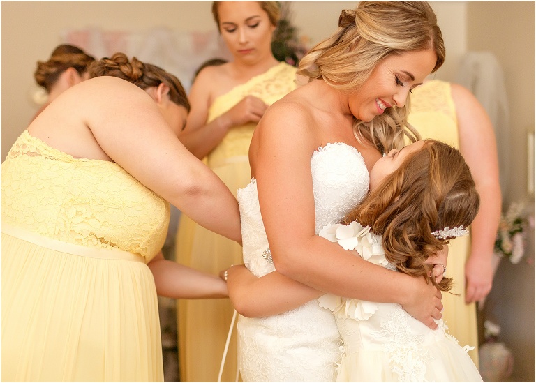 flower girl gives the bride a hug as she prepares for her Cottom Farm wedding