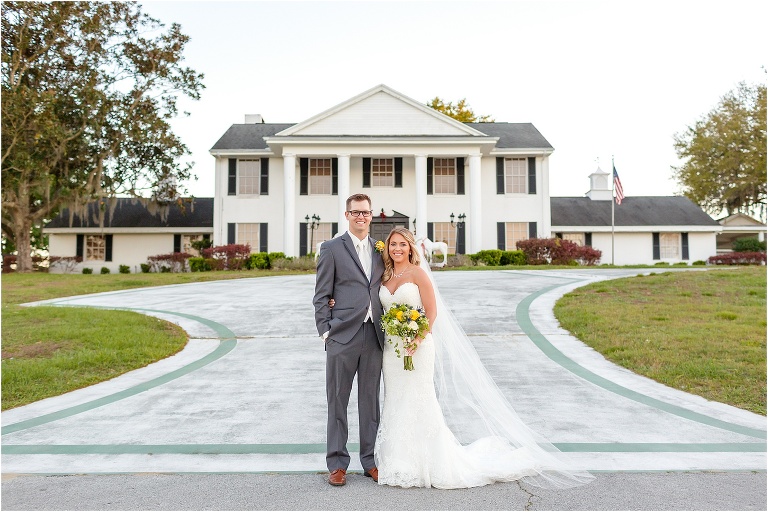 the bride & groom smile together in front of the house at their Cottom Farm wedding