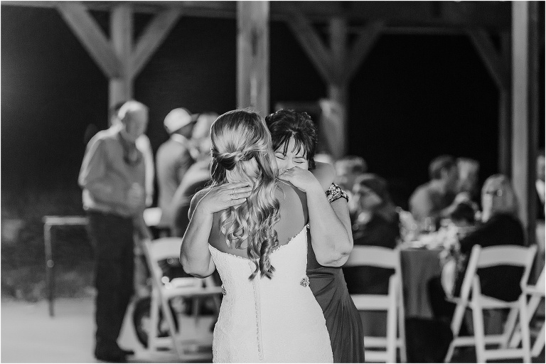 the mother of the bride cries and holds her daughter tight during their mother daughter dance