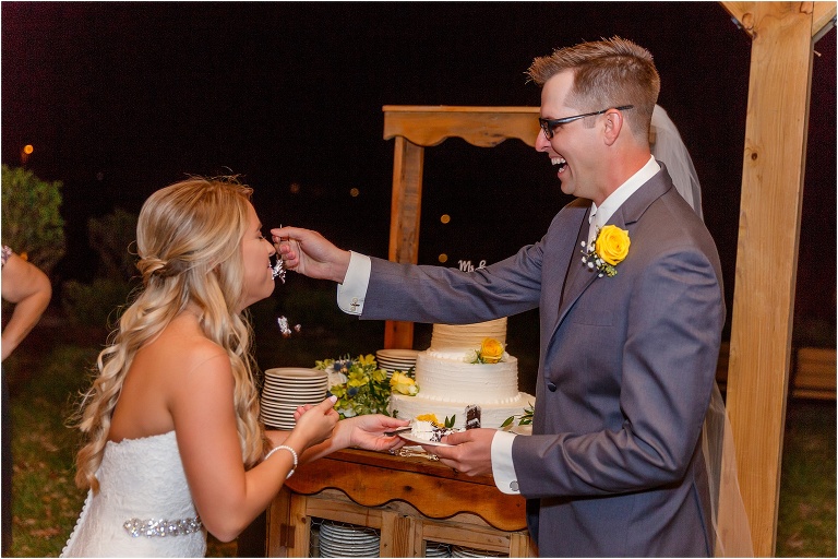 the groom laughs as he feeds his bride their Publix wedding cake at their Cottom Farm wedding reception