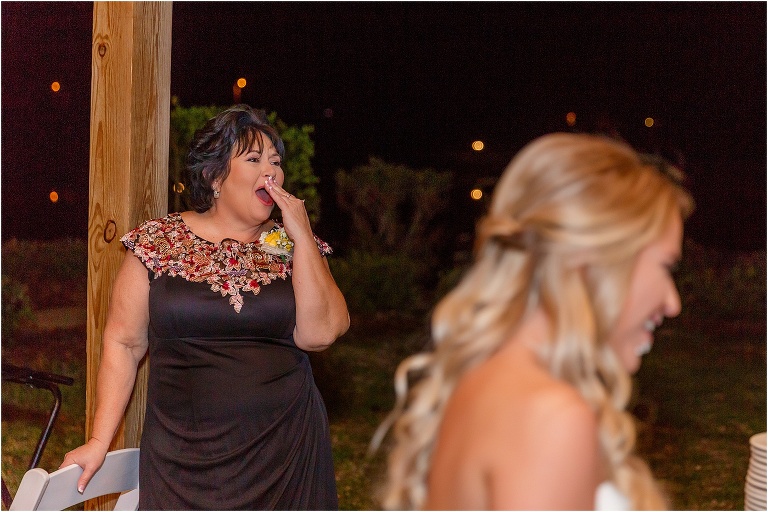 the mother of the bride laughs as the bride & groom feed each other their Publix wedding cake