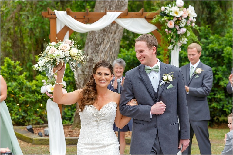 the bride cheers as she walks down the aisle with her new husband at their Bakers Ranch wedding