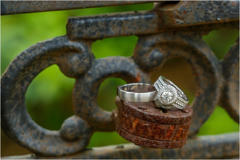the bride & groom's wedding rings on top of a rusty lock at their Bakers Ranch wedding