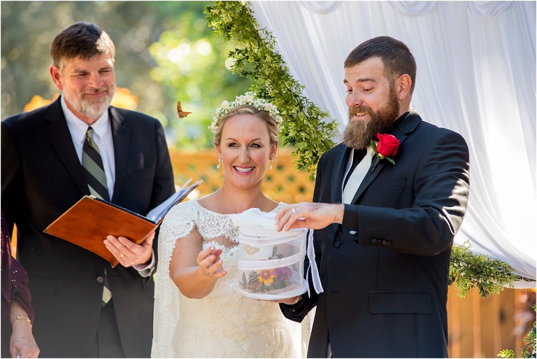 bride & groom release a beautiful monarch butterfly during their Harmony Gardens wedding ceremony
