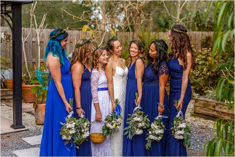 the bride laughs with her bridesmaids in their navy blue dresses