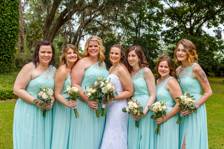 the bride surrounded by her bridesmaids in their teal David's Bridal dresses