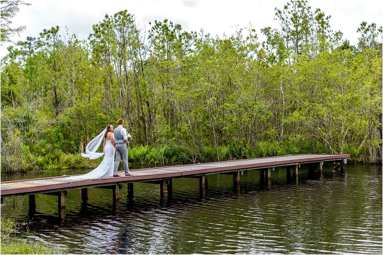 the bride and groom walk down the dock together