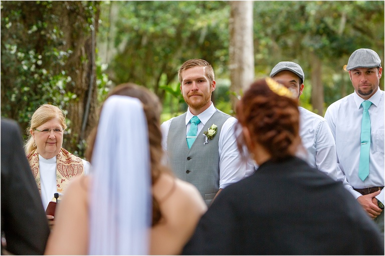 the groom holds back tears as his bride is walked down the aisle to him by her parents