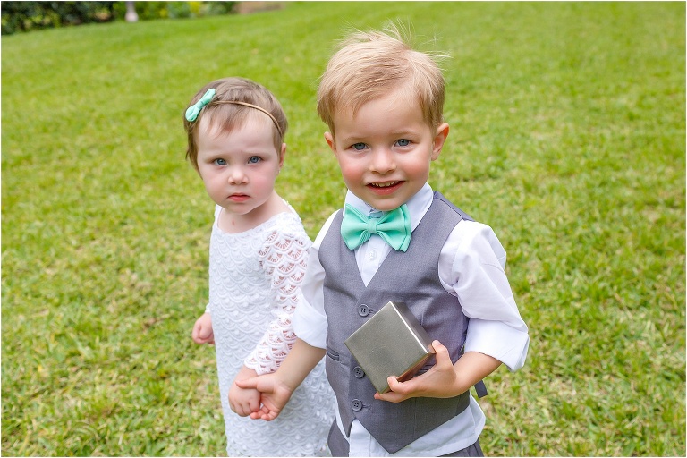 the adorable ring bearer and flower girl hold hands before the Bellemoor Plantation wedding