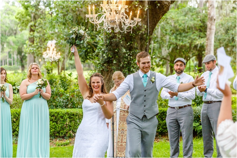 the bride & groom cheer as they walk back down the aisle of their Bellemoor Plantation wedding ceremony