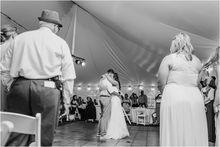 their guests look on as they share their first dance under the white tent at their Bellemoor Plantation wedding reception