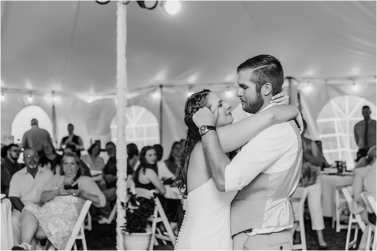 the groom wipes a tear from his bride's eye during their first dance as husband and wife