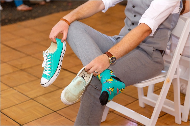 the groom holds one of each shoe during the shoe game